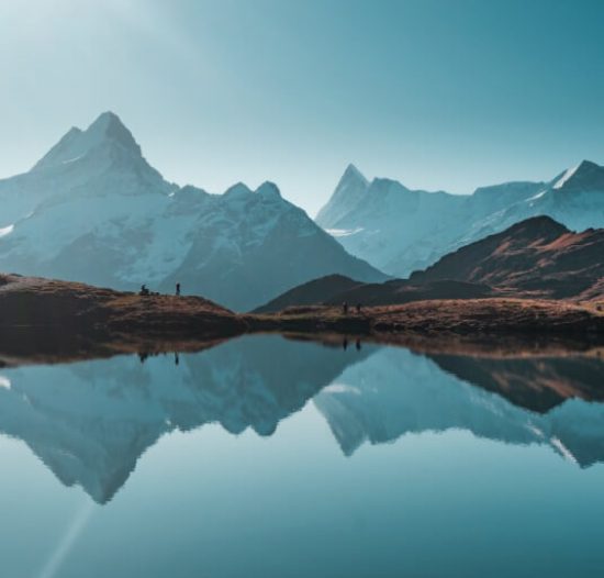 Snow-capped mountains reflected in a still lake
